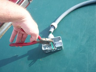 Using an electricians pliers to remove the locknut